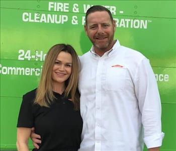 Woman and man in front of green truck