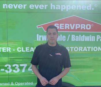 Man in black shirt in front of green background