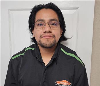 Man in black shirt, white door behind