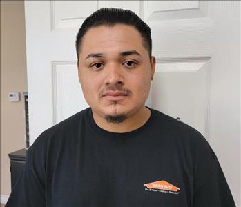 Man in black shirt, white door behind