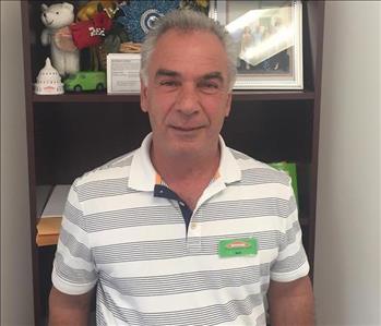 man in striped shirt in front of shelf